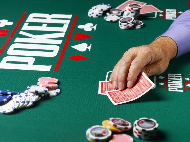 Poker Strategy - Player holding cards in a live game 